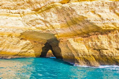 Albufeira, Portekiz - 20 Ocak 2016: Canlı mavi suların görkemli kaya oluşumlarıyla buluştuğu Albufeira Algarve 'de çarpıcı bir kıyı mağarası keşfetmek.