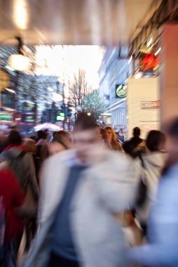 Londra, Birleşik Krallık - 20 Mart 2009: Londra 'nın canlı bir caddesinde, ışıklar yanıp sönerken ve potansiyel yağmura karşı tutulan şemsiyelerle kalabalık koşuşturuyor.