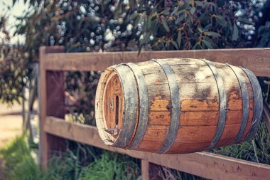 Melbourne, Avustralya - Ekim 07 2009: Kırsal ahşap bir varil, Victoria Avustralya 'da yeşil yapraklarla çevrili ahşap bir çitin üzerinde, büyüleyici bir manzara yakalıyor..