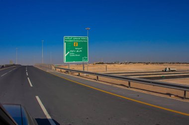 Doha, Katar - 28 Ocak 2010: Açık bir yol işareti, Doha Katar 'daki Salwa Yolu üzerindeki Meleased Community Area' nın mavi gökyüzü altındaki girişini gösteriyor.
