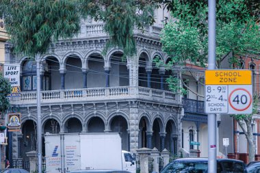 Melbourne, Avustralya - 08 Ekim 2009: Süslü mimarisi olan klasik bir Viktorya dönemi binası Victoria Avustralya 'da gün ışığında bir okul alanı tabelasının yanında duruyor.