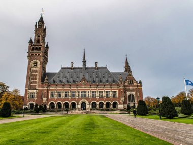 Lahey, Hollanda - 07 Kasım 2018: İnsanlar Den Haag Hollanda 'daki Barış Sarayı' na yaklaşan çimlerde ve patikada yürüyor. Bu sonbahar gününde gökyüzü bulutlu..