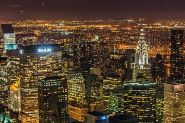 New York, ABD - 22 Eylül 2009: Parlak şehir ışıkları Manhattan 'daki gökdelenleri aydınlatmakta ve gökdelenleri gökyüzünden ikonik binalar ve kentsel titreşimler göstermektedir.