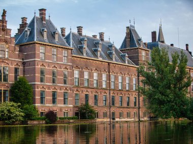 Lahey, Hollanda - 14 Haziran 2009: Binnenhof 'u inşa eden tarihi hükümet bulutlu bir günde Lahey Hollanda' daki bir kanal veya gölete yansıyor.