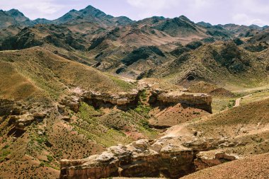 Almaty, Kazachstan - 16 Haziran 2017: Charyn Kanyonu Kazakistan 'ın engebeli tepeleri ve verimli vadileri gün ışığında berrak bir gökyüzü altında gösteren engin dağ manzarası.