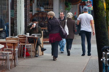 Vancouver, Kanada - 30 Ekim 2009: Kafeler ve dükkanların İngiliz Kolombiya 'sında günlük hayatı yakaladığı yoğun Vancouver caddesi boyunca yürüyen kalabalık.