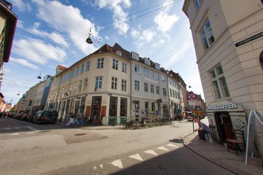 Kopenhag, Danimarka - 17 Mayıs 2010: Güneşli bir günde yerel kültür ve kentsel mimarinin sergilendiği Kafeler ve dükkanlarla Kopenhag 'da canlı bir cadde.