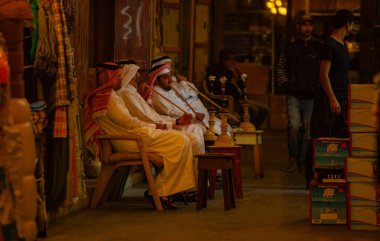 Doha, Katar - 26 Ocak 2010: Geleneksel elbiseli erkekler Doha Katar 'da bir pazarda atmosferin ve sohbetin tadını çıkarıyorlar.