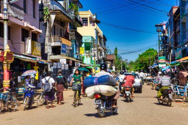 Bago, Myanmar - 02 Aralık 2012: İnsanlar ve araçlar Balo Myanmar 'ın berrak mavi gökyüzü altında günlük yaşamı ve ticareti gösteren canlı sokaklarında geziniyorlar.