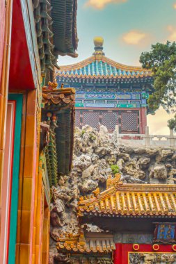 Pekin, Çin - 19 Temmuz 2010: Canlı antik yapılar, Pekin 'in tarihi bir bölgesinde yemyeşil alanlar arasında karmaşık tasarım ve renkler sergiliyor.
