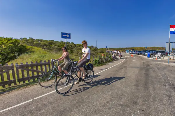 Wassenaar, Hollanda - 18 Mayıs 2014: Wassenaar Hollanda 'nın kum tepelerindeki popüler bisiklet yolunda iki genç sevinçle bisiklet sürüyor
