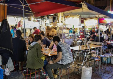 Taipei, Tayvan - 30 Kasım 2016: İnsanlar Taipei 'nin ünlü gece gıda pazarlarından birinde toplanıp yemeklerini paylaşıyorlar ve yerel tatların ve canlı atmosferin tadını çıkarıyorlar.