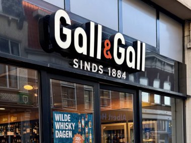 Den Haag, Hollanda - 24 Ekim 2024: Gall and Gall mağazasının vitrininde çeşitli içecekler sergilenen viski promosyonları yer alıyor