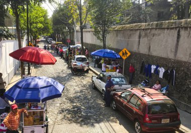 Mexico City, Meksika - 02 Şubat 2017: İnsanlar geçerken bir kadın Mexico City kaldırımında battaniyeden renkli hediyeler satıyor.