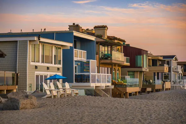Oxnard, ABD - 21 Şubat 2020: Renkli ahşap kiralama mülkleri sakin bir günbatımı sırasında Oxnard California plajı boyunca güzel bir şekilde dizilmiştir.