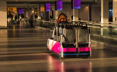 Amsterdam, Hollanda - 18 Ekim 2022: Amsterdam Schiphol havaalanı terminalinde özel ihtiyaçları olan engelli arabası