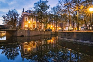 Lahey, Hollanda - 28 Eylül 2017: Hollanda 'nın tarihi kanal evleri, Lahey' deki gece sularını yansıtıyor ve sakin bir atmosfer yaratıyor