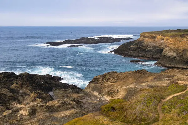 Mendocino, ABD - 16 Şubat 2020: Mendocino 'daki körfez kayalıklarının ve körfezlerin manzarası kayalara çarpan engebeli kıyı şeridini ve dalgaları vurguluyor.