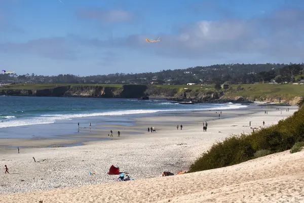 Carmel, ABD - 19 Şubat 2020: Çocuklar Carmel 'de manzaralı bir plajda uçurtma uçururken çakıl taşı plajı golf sahası görülebiliyor..