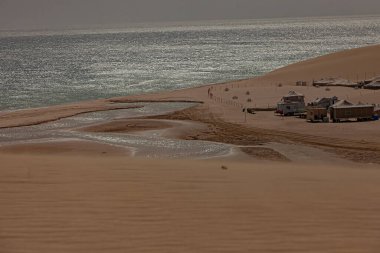 Doha, Katar - 28 Ocak 2010: Altın kumlar Doha kıyısı boyunca sakin sularla buluşuyor ve sakin bir manzara ve huzurlu bir çevre sergiliyor.