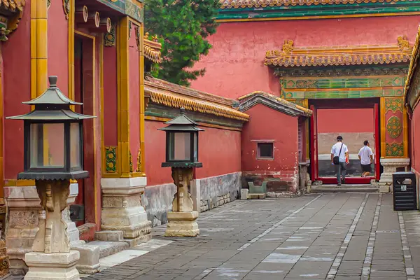 Pekin, Çin - 19 Temmuz 2010: Ziyaretçiler sakin bir günde dekoratif mimari ve fenerlerle sıralanmış geleneksel Pekin sarayı avlusunda geziyorlar.