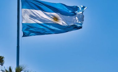 Arjantin 'in ulusal mavi beyaz bayrağı. Havada bir direkte sarı işaretler var.