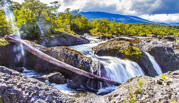 Puerto Varas, Şili - 10 Kasım 2014: Petrohue Nehri 'ndeki kayaların üzerinden taşan vahşi sular, Şili' nin güneyindeki yemyeşil ormanlar ve görkemli dağlarla çevrilidir..