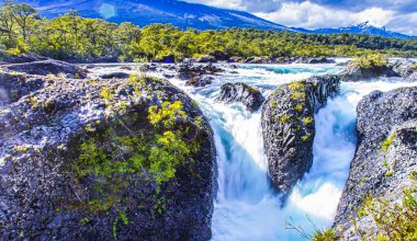 Puerto Varas, Şili - 10 Kasım 2014: Petrohue Nehri 'nin vahşi suları yemyeşil dağlarla çevrili kayaların üzerine dökülüyor