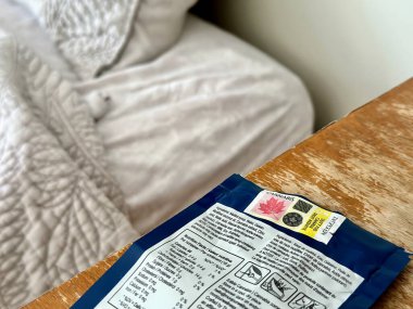 Port Perry, Kanada - Eylül 08 2023: Kenevir hapları yatak odasındaki bir komodinin üzerinde mavi bir çantada sergilenir