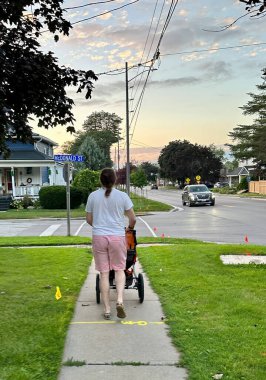 Port Perry, Kanada 'da McDonald Caddesi boyunca yeni doğmuş bebeğiyle gezen özgür bir adam... 25 Ağustos 2023