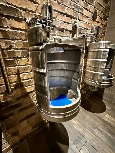 Oshawa, Kanada - Eylül 06 2023: Oshawa 'da bir barda bulunan erkekler tuvaletinde bira kutularından yapılmış pisuarlar eşsiz ve ilginç bir tasarım yaratıyor..