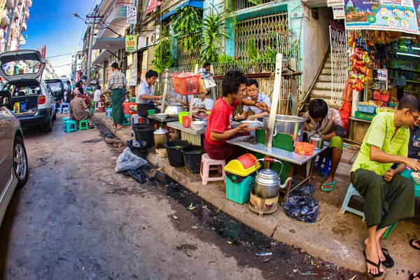 Yangon, Myanmar - 04 Aralık 2012: Yangon 'da yerel halkın gün boyunca canlı bir şehir ortamında yemeklerin tadını çıkardığı işlek sokak yemekleri tezgahları.