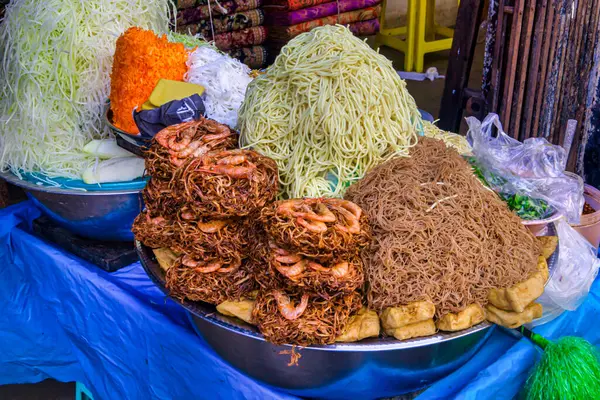 Yangon, Myanmar - 03 Aralık 2012: Yangon 'daki renkli sokak yemekleri çeşitli erişte yemekleri, taze sebzeler ve hevesli müşteriler için yerel tatlar sunuyor.