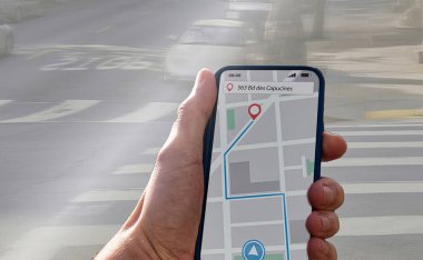Şehir kaldırımında akıllı bir telefondan navigasyonla yürüyen bir insan. kılavuz