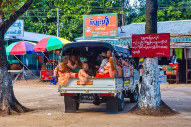 Bago, Myanmar - 3 Aralık 2012: Genç keşişler Myanmars 'ın canlı atmosferinde renkli market tezgahlarıyla çevriliyken bir kamyonun arkasında dinleniyorlar.