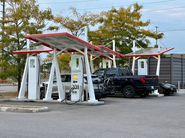 Oshawa, Kanada - 17 Eylül 2023: Oshawa Kanada 'daki hızlı şarj istasyonuna bir elektrikli araba yanaştı..