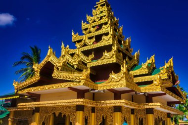 Bago, Myanmar - 03 Aralık 2012: Myanmar 'da parlak mavi gökyüzüne karşı çarpıcı bir altın pagoda yükseliyor..