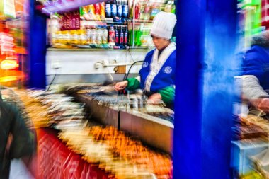 Chengdu, Çin - 28 Kasım 2009: Bir satıcı Chengdu Çin 'de lezzetli sokak yemekleri hazırlıyor canlı renkler ve gece piyasalarının hareketli enerjisi sergiliyor.