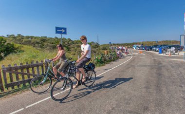 Wassenaar, Hollanda - 18 Mayıs 2014: Kum tepelerindeki Hollanda bisiklet yolunda bisiklet sürerken eğlenen iki genç