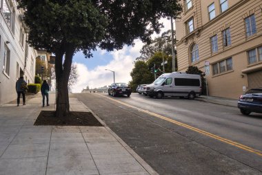 San Francisco, Amerika Birleşik Devletleri - 14 Şubat 2020: Tipik San Francisco sokağı park etmiş arabalar ve Viktorya dönemi evleriyle dolu dik bir yokuş.