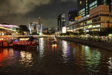 Singapur, Singapur - 29 Kasım 2012: Singapur Nehri geceleri restoran tekne gezileri ve liman boyunca canlı ışık gösterimiyle parlıyor.