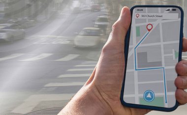 Kişi şehir kaldırımında bir navigasyon cihazıyla yürüyor.