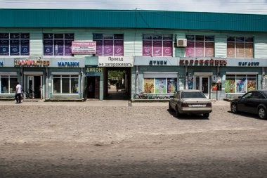 Almaty, Kazachstan - 16 Haziran 2017: Almatı 'da çeşitli dükkanları ve açık bir gökyüzü altında park edilmiş arabaları olan alışveriş merkezi. İnsanlar şehir hayatının tadını çıkarıyorlar..