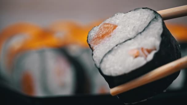 寿司卷是用筷子进行寿司特写的 在餐馆里吃日本料理寿司 寿司卷鲑鱼和蔬菜 日本餐馆菜单 侧视图 — 图库视频影像
