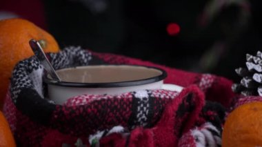 Girl drinks coffee in cozy New Years atmosphere on background of Christmas tree. New Years Eve alone. Screensaver in a cozy atmosphere. The aroma of coffee in a warm cozy blanket.