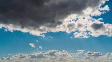 Beyaz kabarık bulutlar mavi gündüz vakti gökyüzünde yavaşça süzülür. Güzel gökyüzü hareket ediyor. Kar beyazı bulutlar yana doğru hareket ediyor..