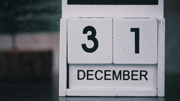 女人的手把白色木日历上的日期改到新年 2023年新年和冬季气氛 12月31日至1月1日一个重要事件的木制日历 — 图库视频影像