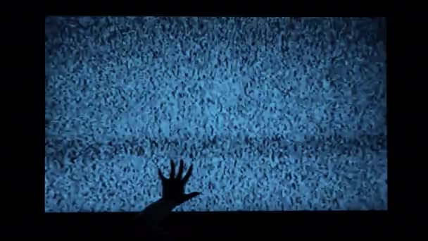 ホラー映画のためのテレビの怖いシーンのノイズの背景に手 怖い魔女の手は テレビ画面に登る 爪とテレビ画面上の干渉と手のシルエット — ストック動画