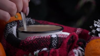 Girl drinks coffee in cozy New Years atmosphere on background of Christmas tree. New Years Eve alone. Screensaver in a cozy atmosphere. The aroma of coffee in a warm cozy blanket.