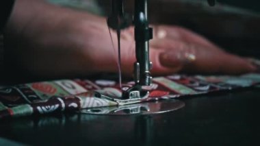 Klasik dikiş makinesi iğnesi yavaş çekimde. Dikiş makinesinin iğnesinin yakın çekimi. Hızla yukarı aşağı hareket ediyor. Bir terzi dikiş atölyesinde kumaş diker. Kumaş dikme süreci.